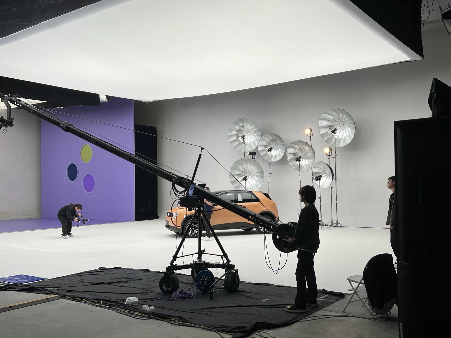 Camera crane and lighting in a studio set with a firefly car