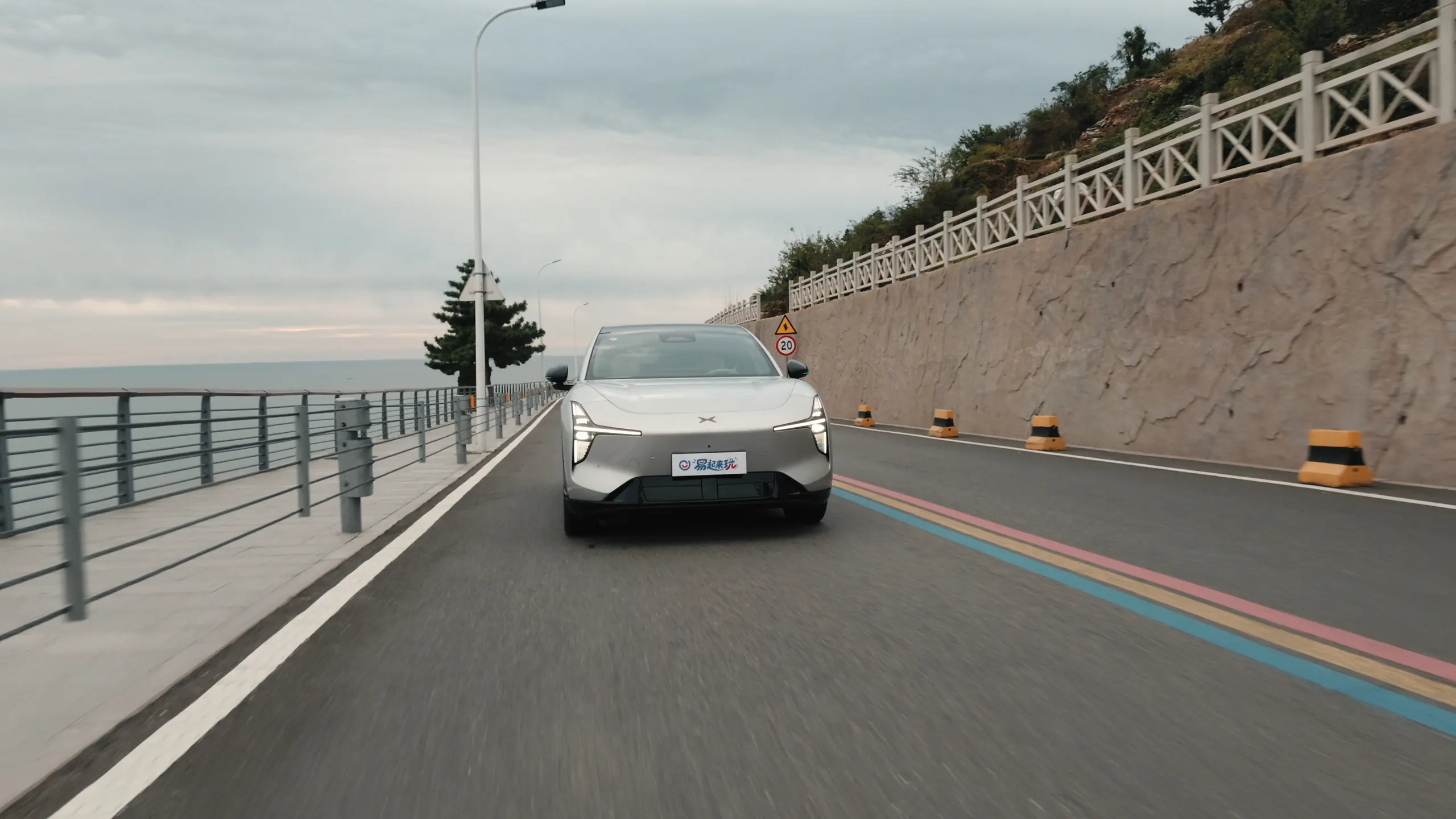 A silver XPENG MONA L05 on a coastal road during the Golden Outer Ring drive